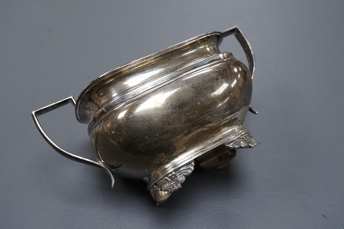 A George V silver two handled sugar bowl, by Goldsmiths & Silversmiths Co Ltd, Sheffield, 1923, with engraved initial, on four winged paw feet, length `7.1cm over handles, 8.5oz.